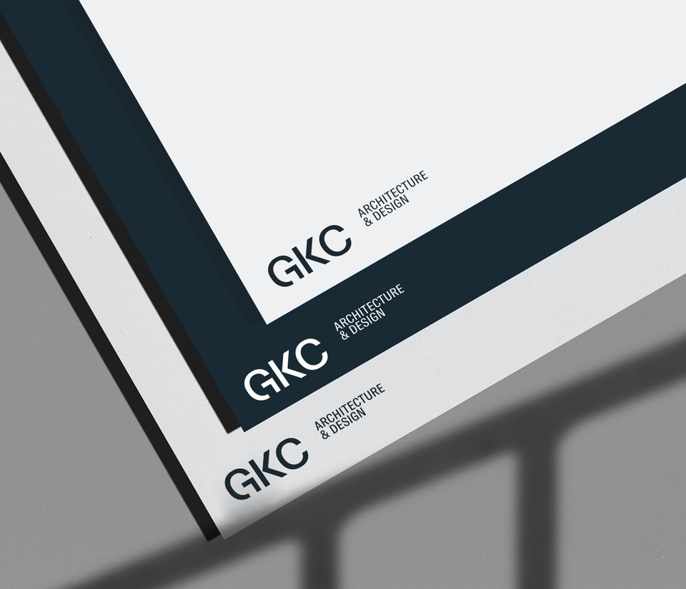 Applications of the new logo on three letterhead sheets, each in one of the new GKC official colours: dark blue, gray and white.